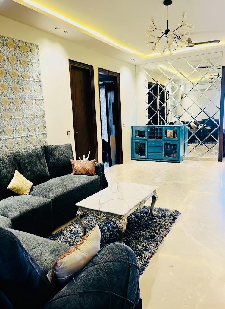 Contemporary lounge with diamond mirror wall, sputnik chandelier and velvet sectional by Assankhhya