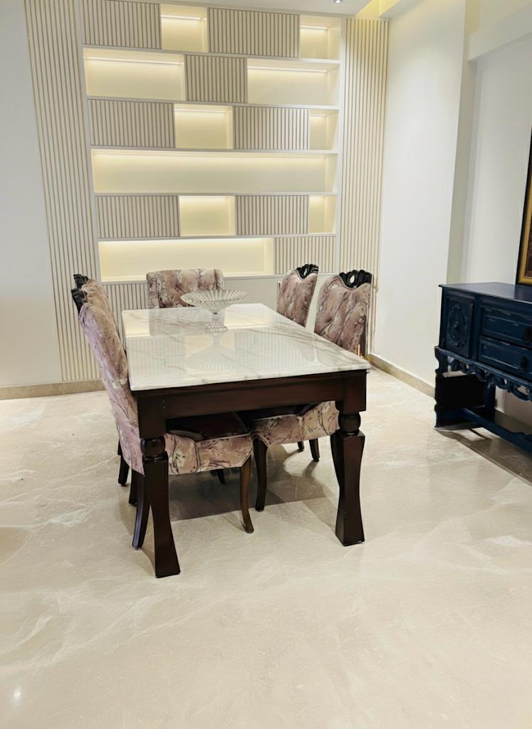 Elegant dining area with marble table, designer chairs and backlit striped shelving by Assankhhya